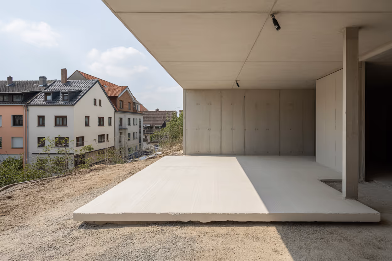 Fertig betonierte Bodenplatte unter einem modernen Neubau mit glatter Oberfläche und sichtbarer Abdichtung